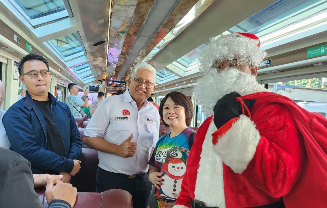 Foto: Direksi KAI Wisata dan KAI Commuter berbagi merchandise Natal kepada penumpang KA Panoramic Argo Wilis di Stasiun Surabaya Gubeng