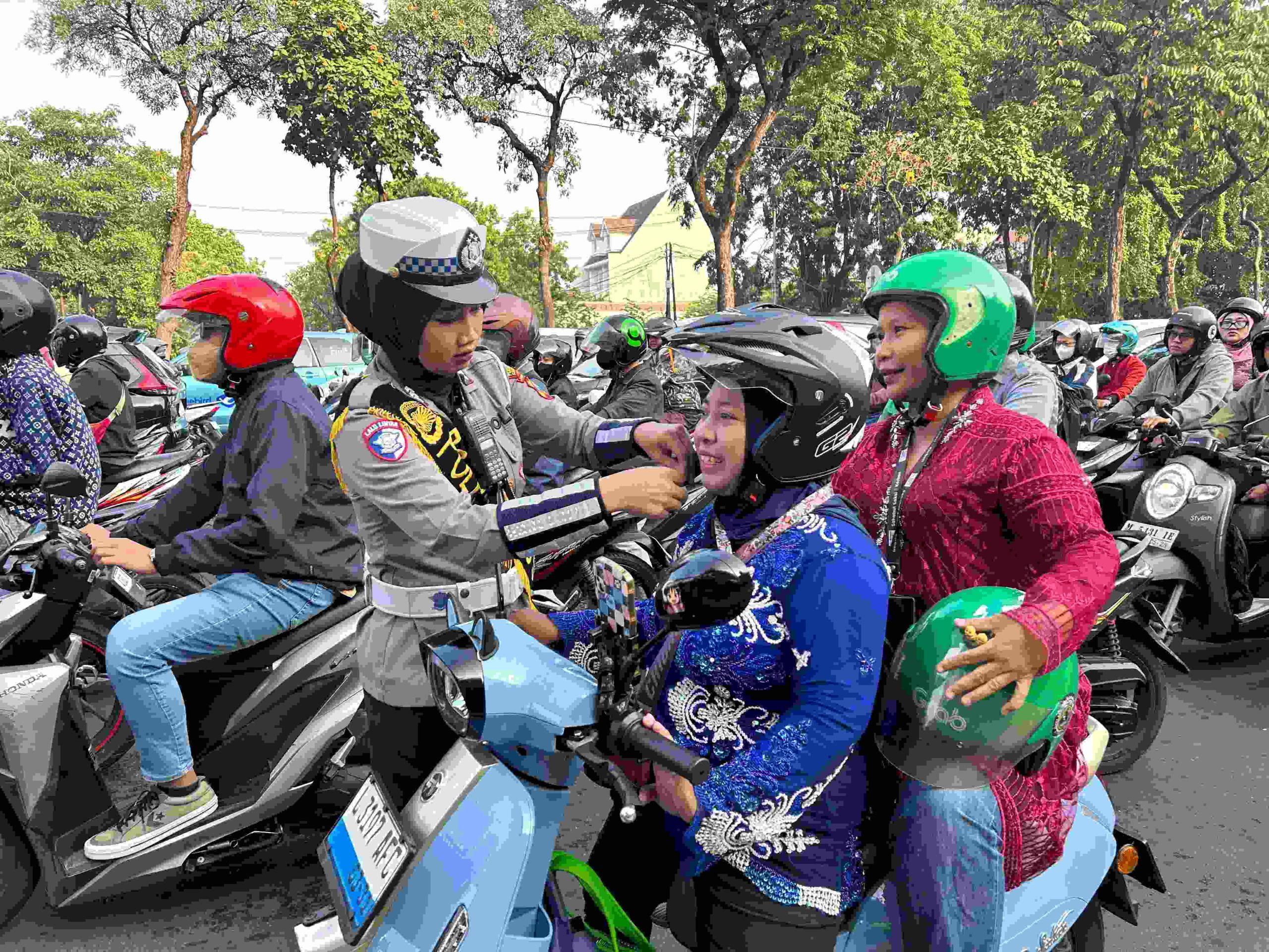 Foto: Polwan Satlantas Surabaya membagikan cokelat dan helm kepada pengendara perempuan di Hari Kartini