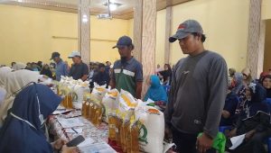 Foto: Warga Desa Bongsopotro antre tertib menerima bantuan beras dan minyak goreng di balai desa Saradan Madiun
