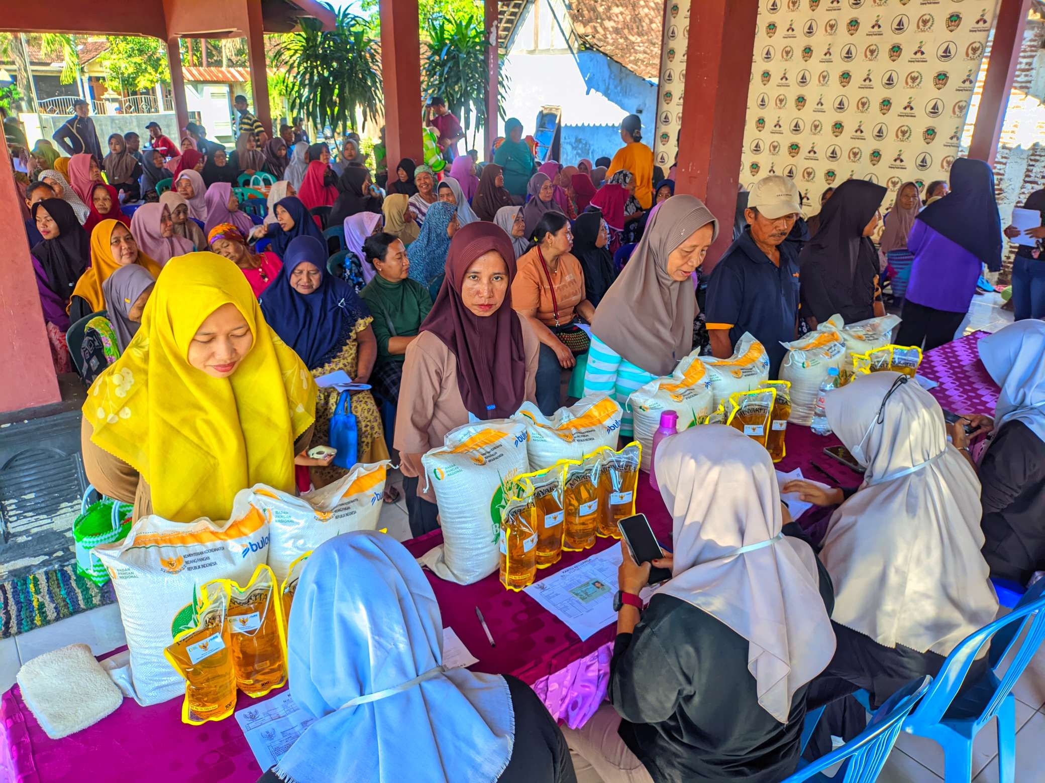 Foto: Penyaluran bantuan beras dan minyak goreng oleh BULOG Madiun kepada warga di Desa Bajulan Kabupaten Madiun