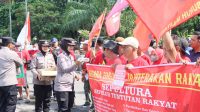 Foto: Polwan Polres Madiun Kota membagikan air mineral kepada peserta aksi May Day 2026 di Alun-Alun Kota Madiun