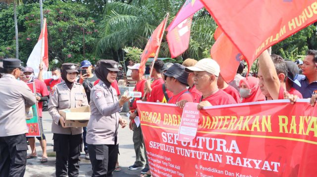 Foto: Polwan Polres Madiun Kota membagikan air mineral kepada peserta aksi May Day 2026 di Alun-Alun Kota Madiun