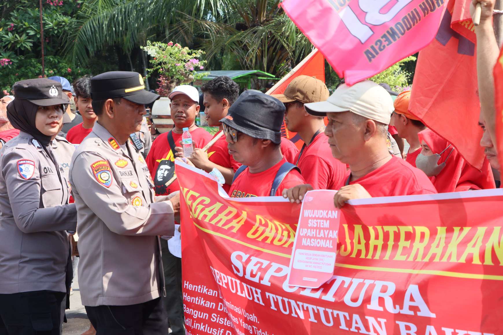 Foto: Polwan Polres Madiun Kota membagikan air mineral kepada peserta aksi May Day 2026 di Alun-Alun Kota Madiun
