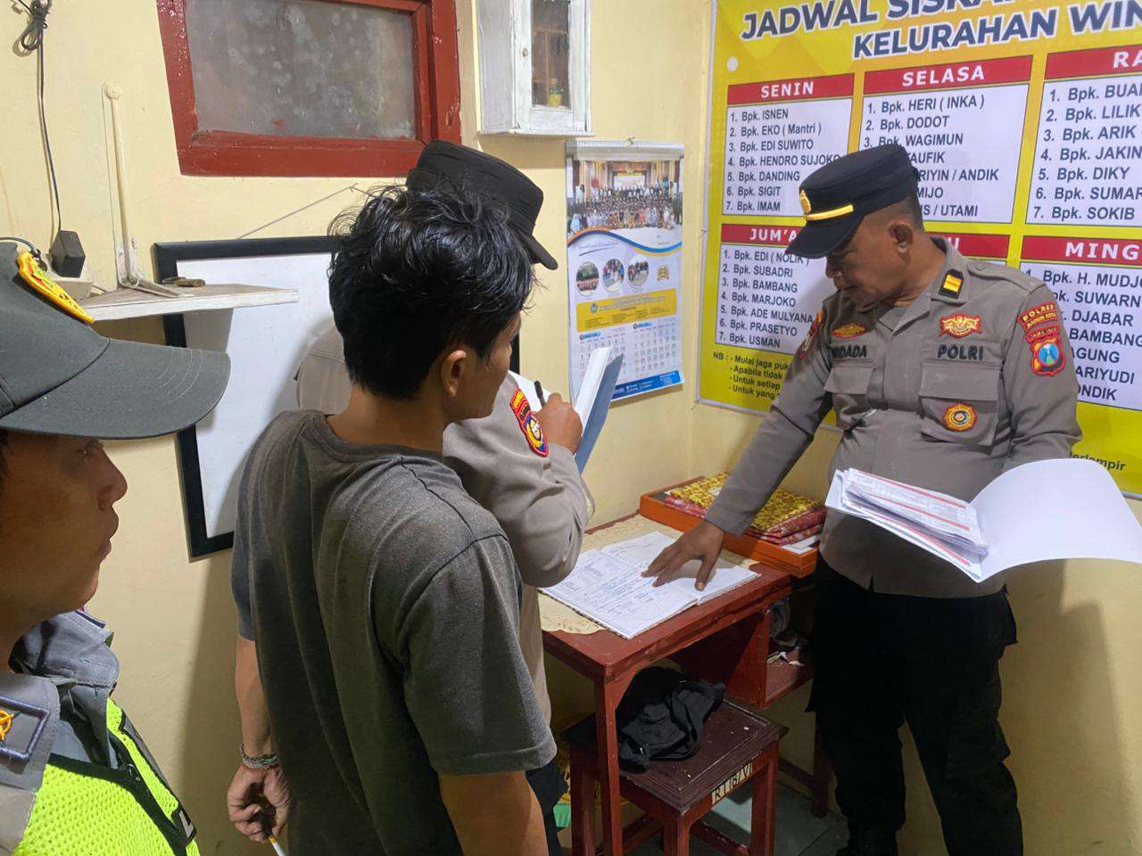 Foto: Petugas Satbinmas Polres Madiun Kota melakukan penilaian pos kamling di Kelurahan Winongo pada malam hari