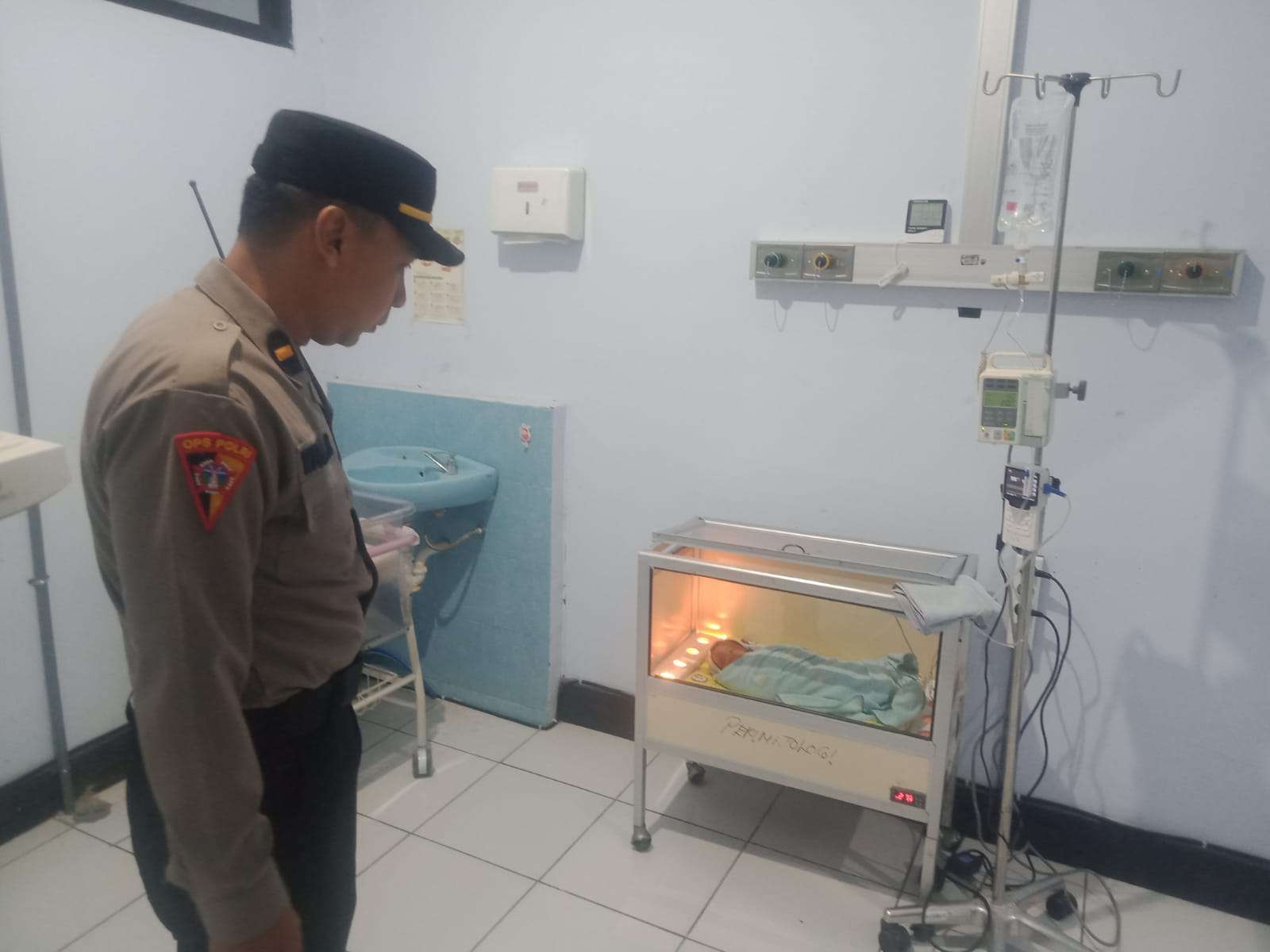 Foto: Petugas kepolisian dan warga saat melakukan evakuasi bayi laki-laki yang ditemukan di area Jembatan Reksogati Kota Madiun.
