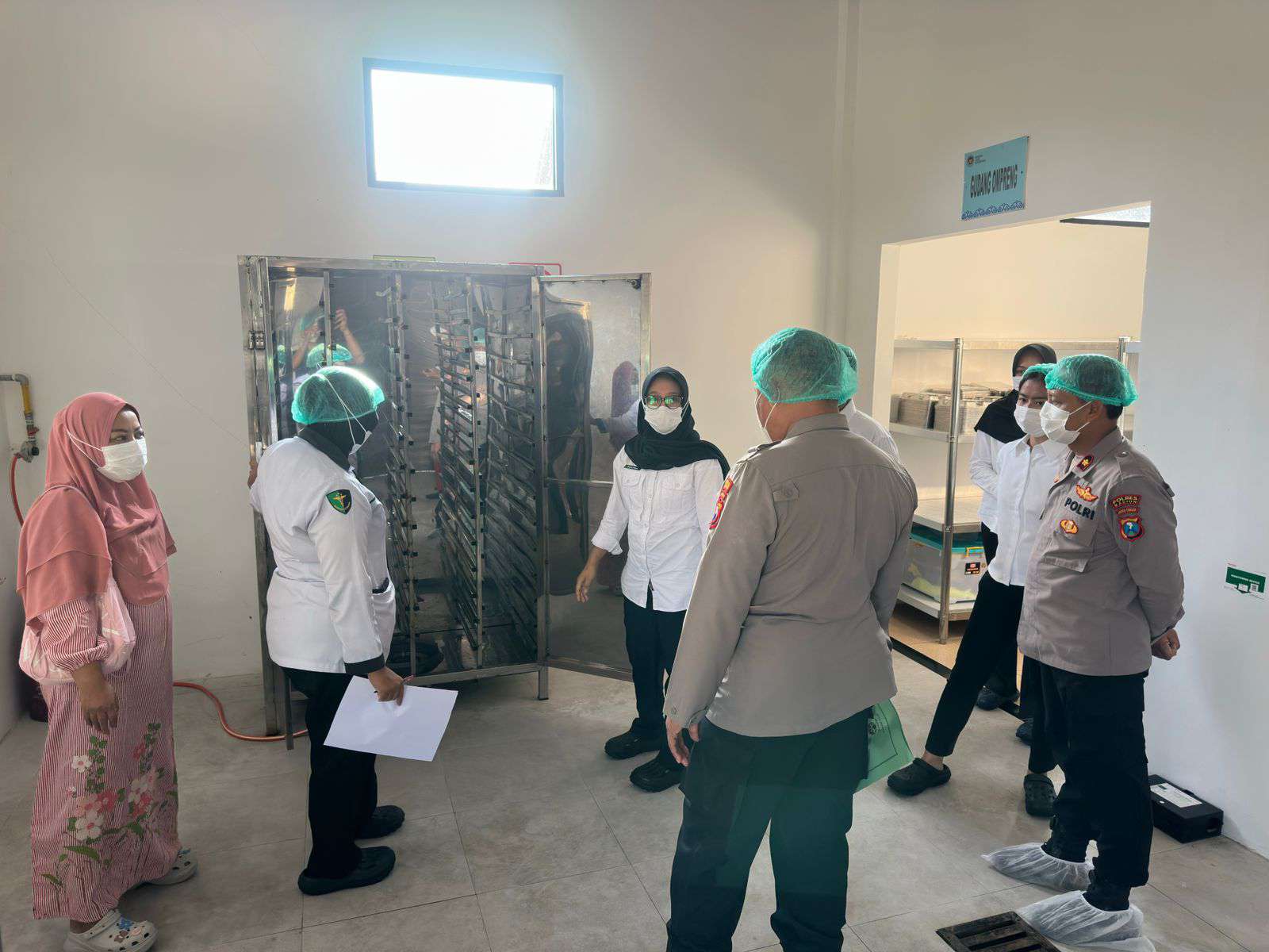Foto: Wakapolres Madiun Kompol Mukhamad Lutfi saat melakukan pengecekan kebersihan dan kualitas makanan di SPPG 2 Polres Madiun.