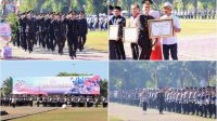 Foto: Kapolres Madiun AKBP Kemas Indra Natanegara menyerahkan piagam penghargaan pada peringatan Hari Bhayangkara ke-80 di Alun-Alun Reksogati Caruban.