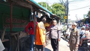 Foto: Petugas gabungan melakukan identifikasi dan evakuasi jenazah seorang pria yang ditemukan meninggal di area stand Pasar Pogot, Surabaya.