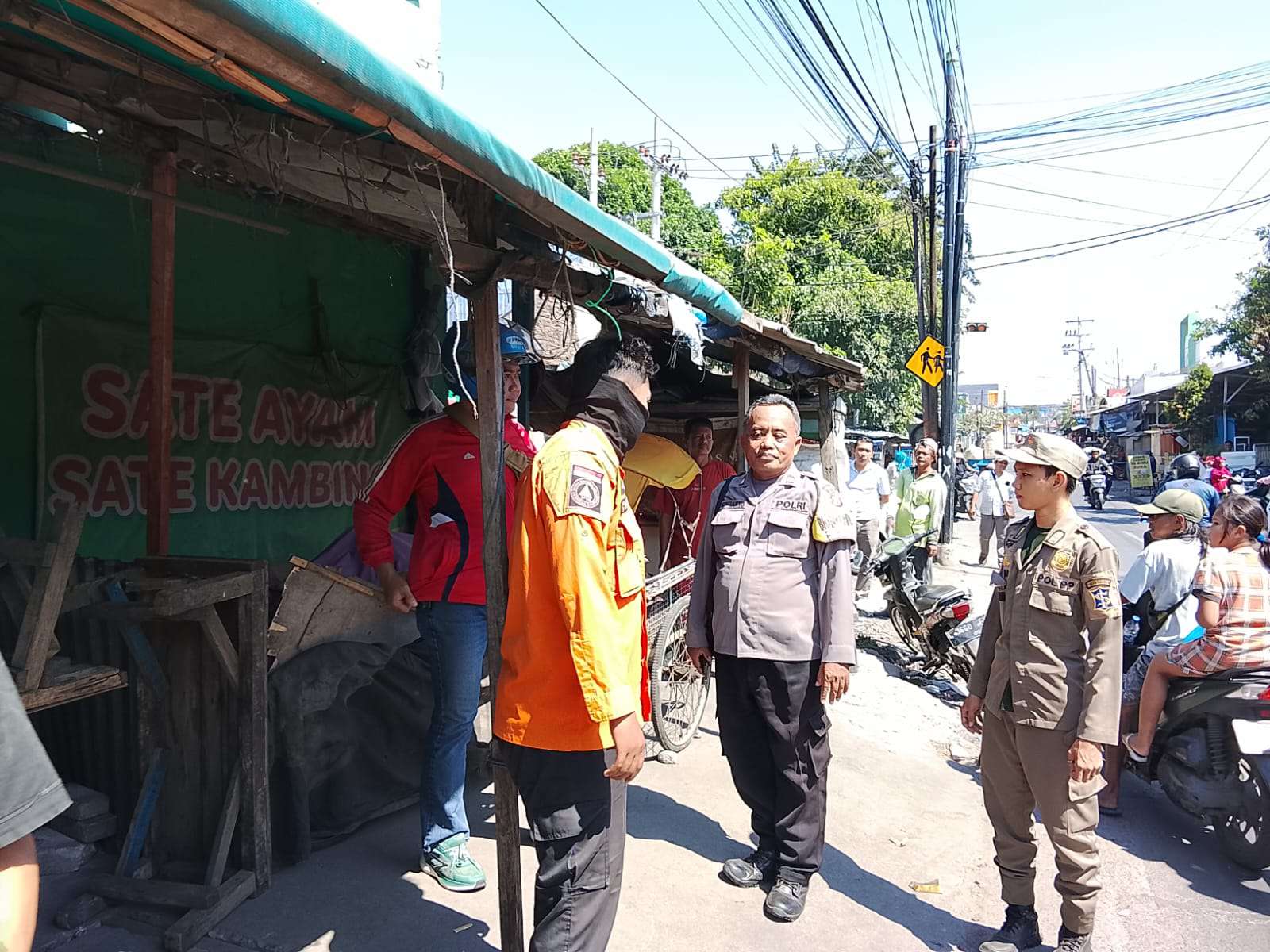 Foto: Petugas gabungan melakukan identifikasi dan evakuasi jenazah seorang pria yang ditemukan meninggal di area stand Pasar Pogot, Surabaya.