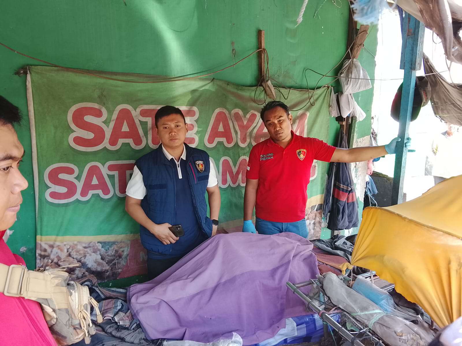 Foto: Petugas gabungan melakukan identifikasi dan evakuasi jenazah seorang pria yang ditemukan meninggal di area stand Pasar Pogot, Surabaya.