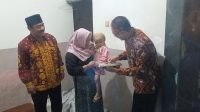 Foto: Kepala Perwakilan Kemendukbangga/BKKBN Jawa Timur Shodiqin menyerahkan bantuan Program GENTING kepada keluarga risiko stunting pada puncak Harganas ke-33 Tahun 2026 di Kabupaten Malang.