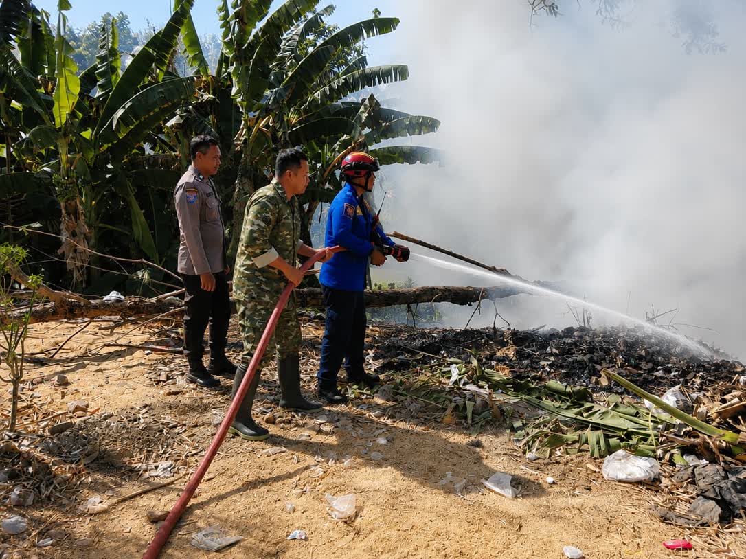 Foto: Babinsa dan petugas Damkar memadamkan kebakaran tumpukan sampah dan pohon bambu di Banjarsari Kulon Madiun
