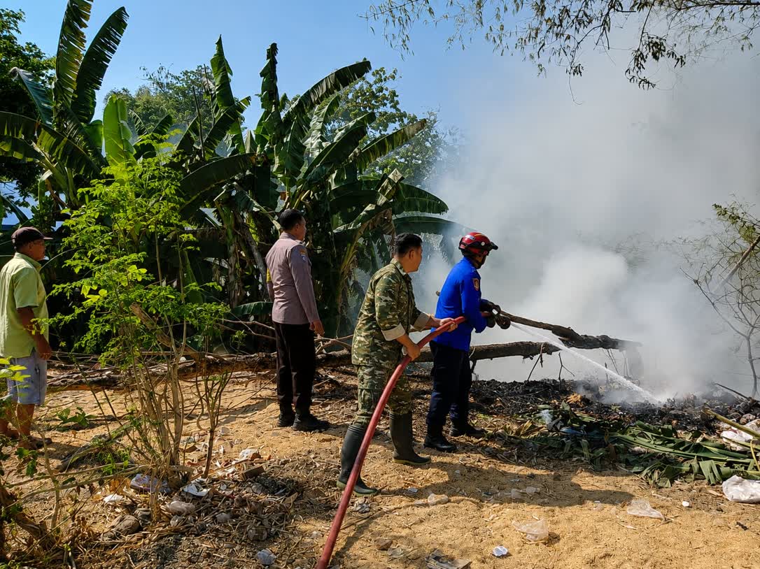 Foto: Babinsa dan petugas Damkar memadamkan kebakaran tumpukan sampah dan pohon bambu di Banjarsari Kulon Madiun