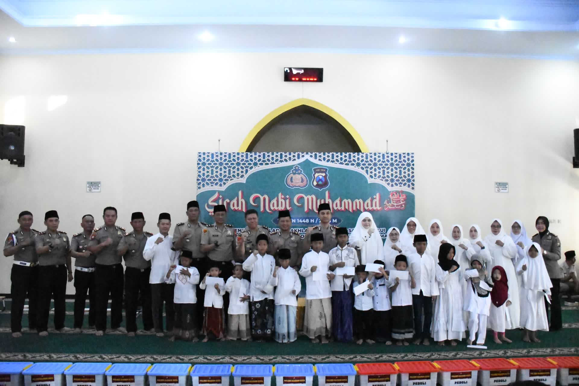 Foto: Kapolres Madiun Kota AKBP Rizki Pratama W.P. menyerahkan santunan dalam peringatan Maulid Nabi Muhammad SAW 1448 H di Masjid Al-Muhlisin.