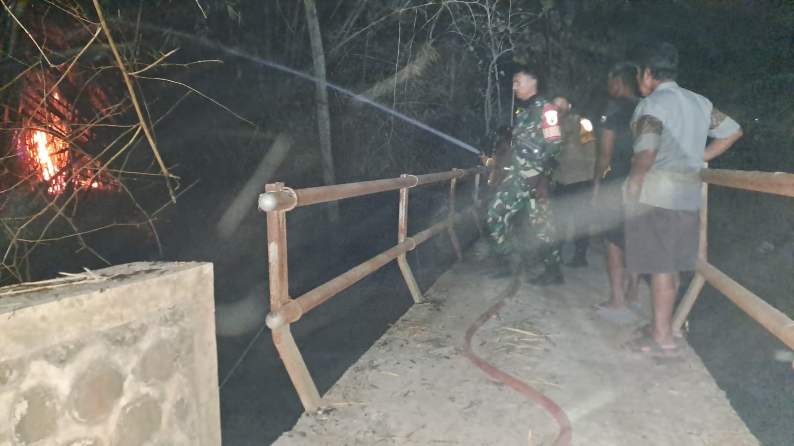 Foto: Babinsa dan petugas Damkar Kabupaten Madiun memadamkan kebakaran rumpun bambu di Dusun Bener, Saradan.