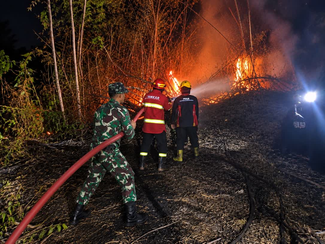 Foto: Petugas BPBD bersama Babinsa dan warga memadamkan kebakaran lahan bambu di Balerejo Kabupaten Madiun