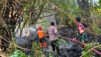 Foto: Petugas memadamkan kebakaran lahan di tanggul irigasi Desa Metesih, Kecamatan Jiwan, Kabupaten Madiun